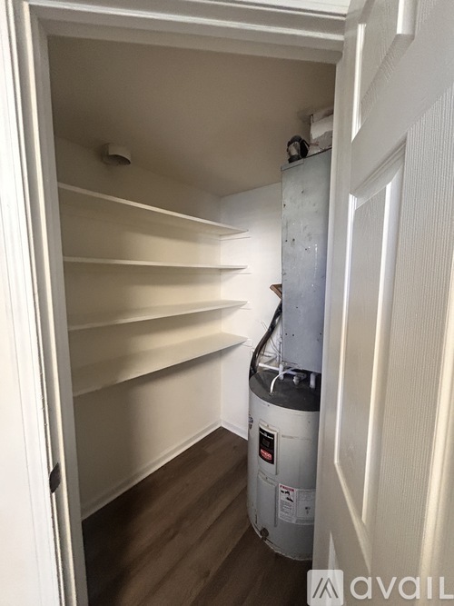 A white door with a shelving unit inside.