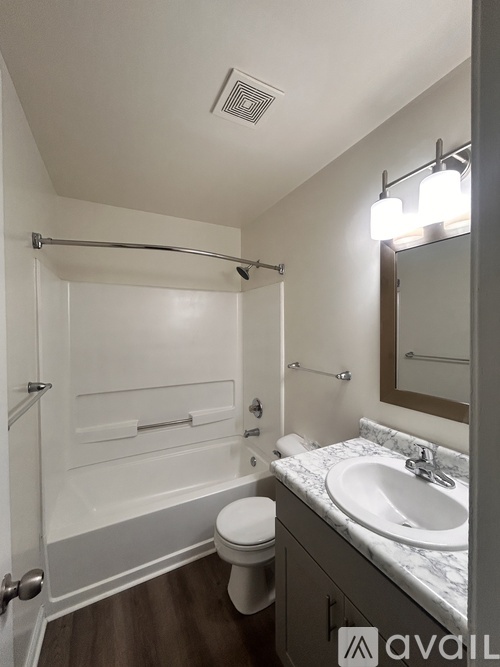 A bathroom with a toilet, sink, and a walk-in shower.