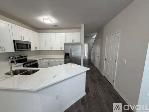A kitchen with white cabinets and a white countertop.