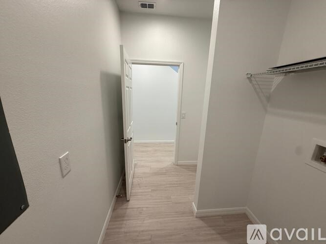 A hallway with a door open to another room.