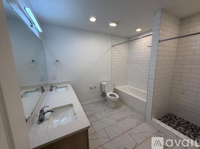 A bathroom with a toilet, sink, and mirror.