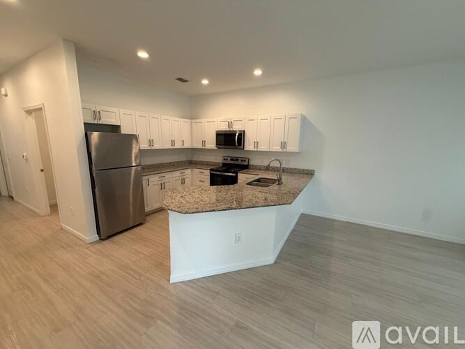 A kitchen with a refrigerator, microwave, and oven.