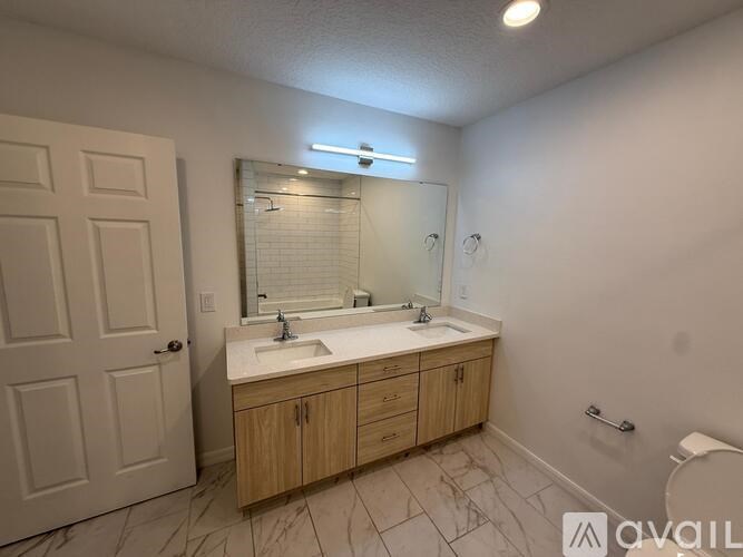 A bathroom with a marble floor and a white door.
