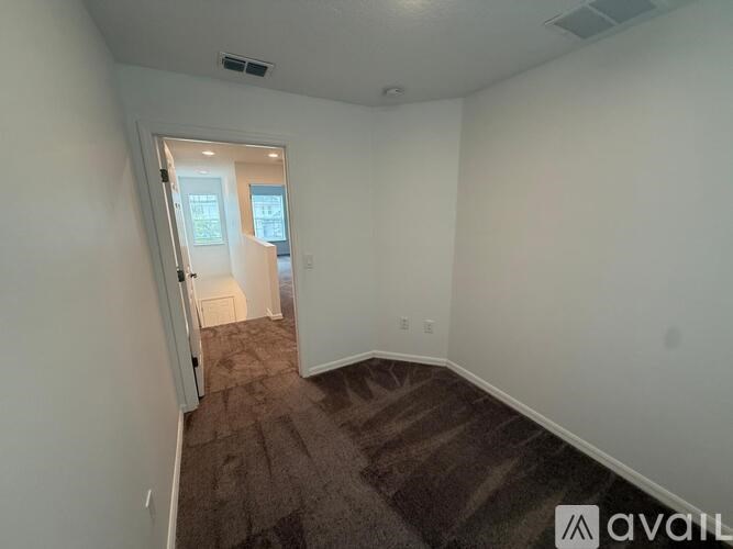 A room with a carpeted floor and a doorway leading to another room.