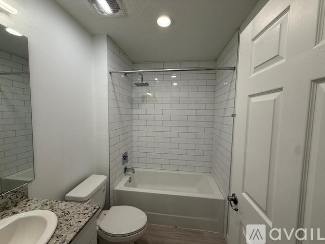 A bathroom with a white tub, toilet, and sink.