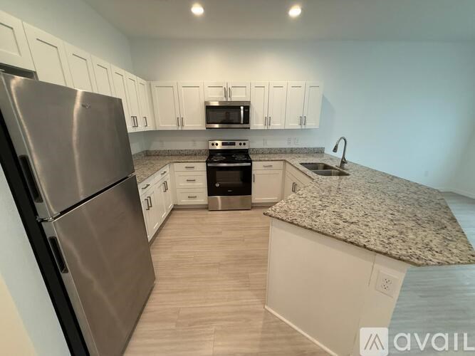 A kitchen with a granite countertop and stainless steel appliances.