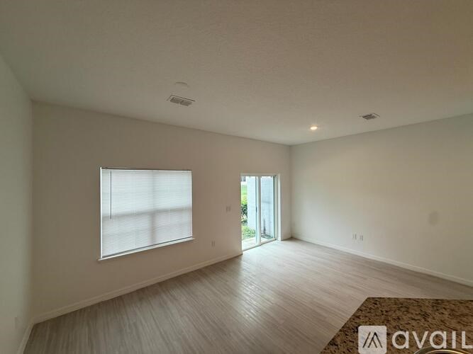 A room with a window and a door leading to a balcony.