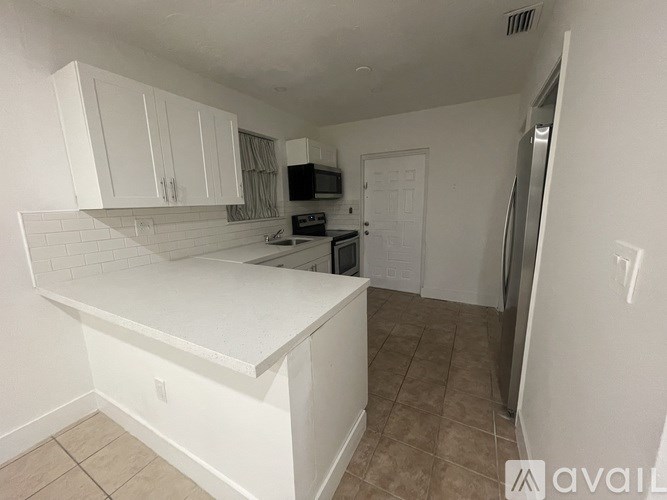 A kitchen with white cabinets and a white countertop.