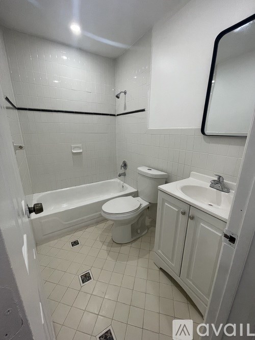A white bathroom with a toilet, sink, and bathtub.