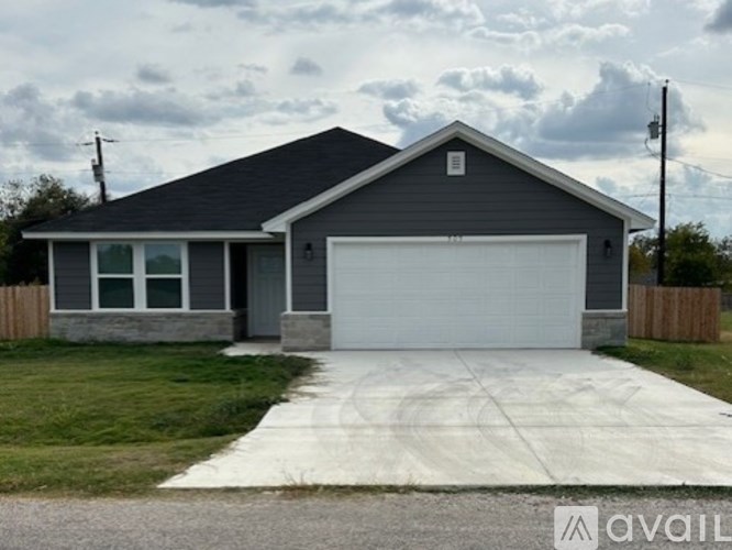 A house with a grey roof and a white garage door.