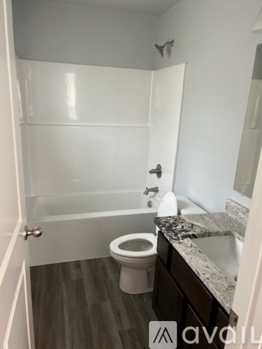 A bathroom with a toilet, sink, and bathtub.
