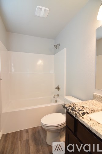 A room with a ceiling fan and wooden flooring.