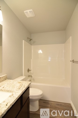 A room with a carpeted floor and a ceiling fan.