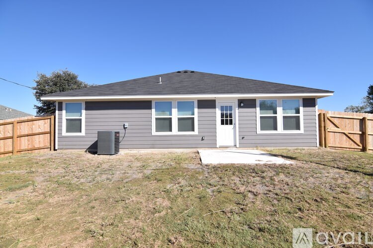 A grey house with a brown fence in front of it.