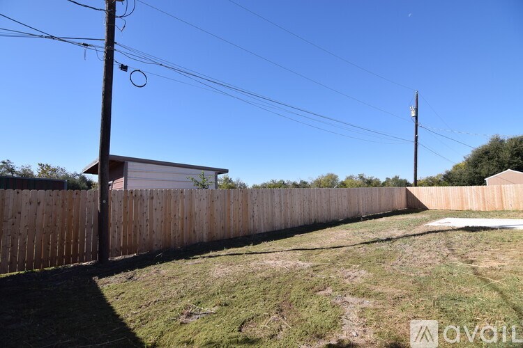 A backyard with a wooden fence and a utility pole.
