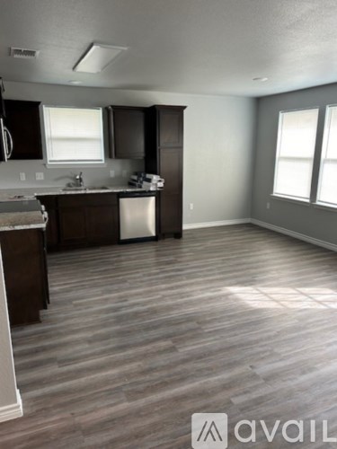 A kitchen with dark wood floors and white appliances.
