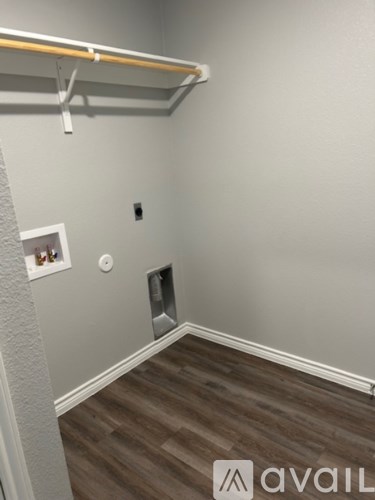 A room with a grey wall and a wooden floor.
