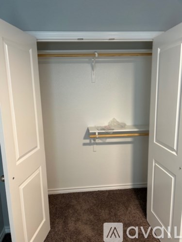 A white closet with a shelf and a hanger.