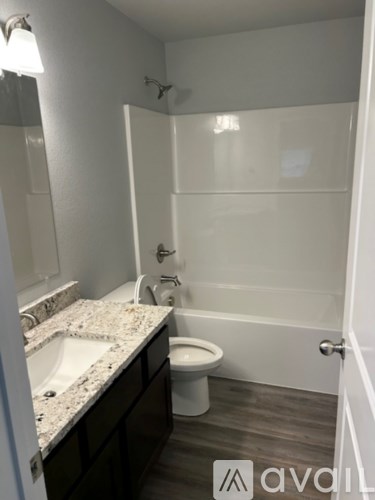 A bathroom with a toilet, sink and bathtub.