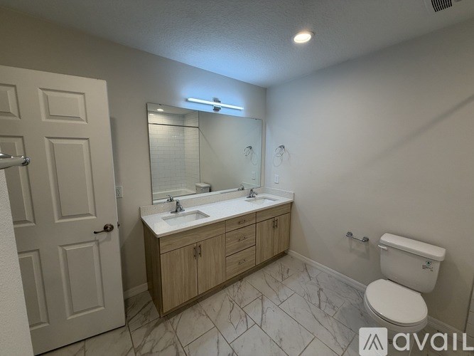 A bathroom with a toilet, sink, and mirror.