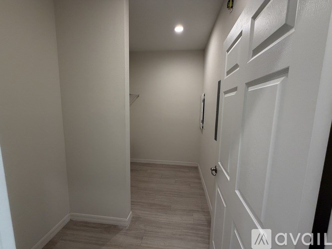 A hallway with a white door and a light on the ceiling.