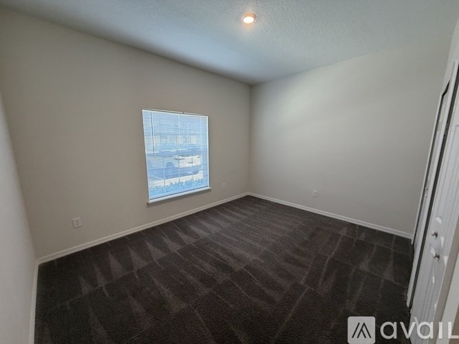A room with a carpeted floor and a window showing a snowy landscape outside.