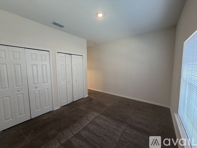 A room with grey carpet and white doors.