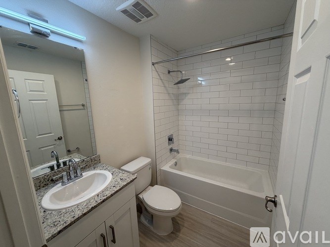 A bathroom with a white toilet, sink, and bathtub.