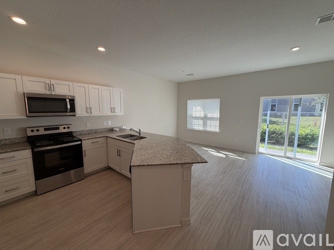 A kitchen with a granite countertop and stainless steel appliances.