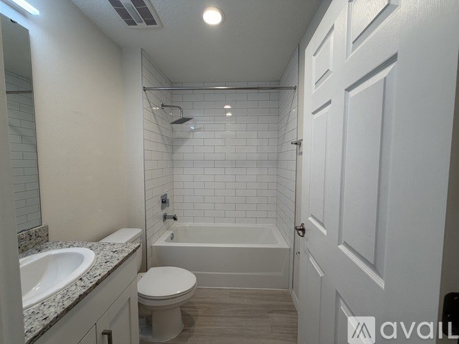 A white bathroom with a toilet, sink, and bathtub.