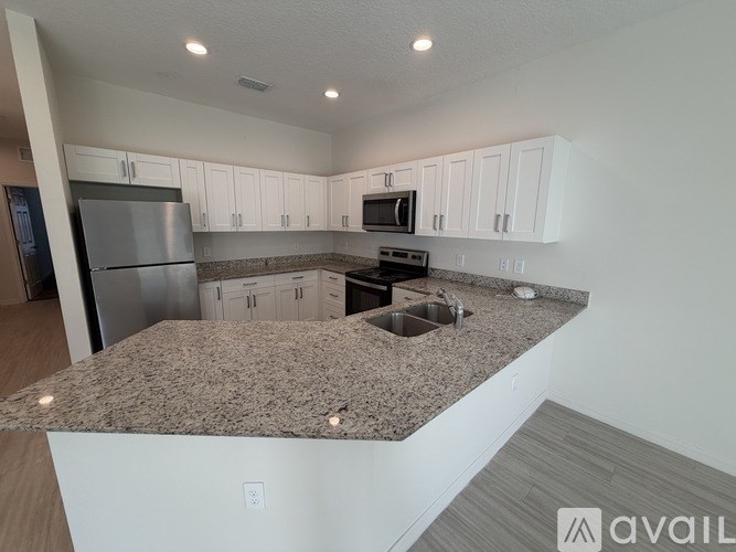 A kitchen with granite countertops and white cabinets.