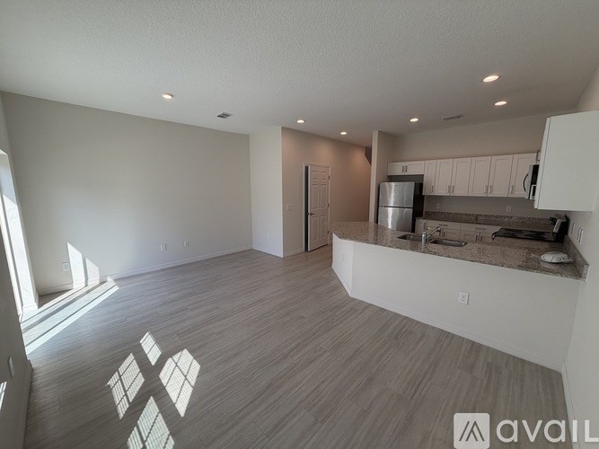 A spacious kitchen with a refrigerator, sink, and cabinets.