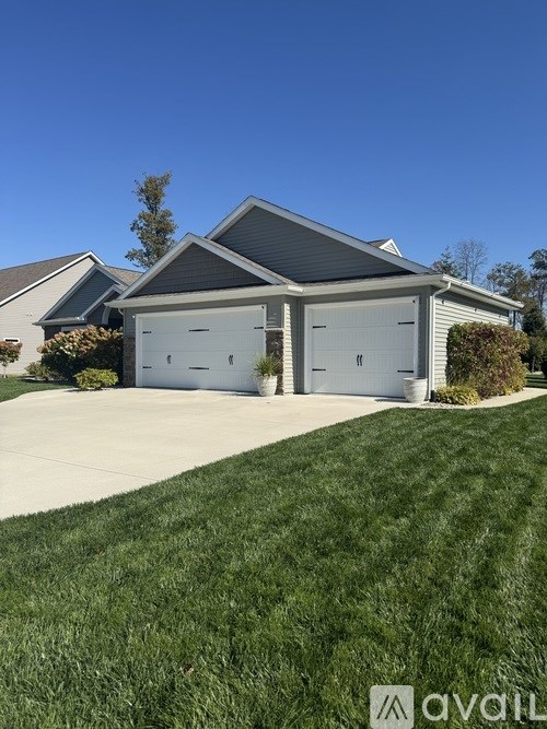 A house with two garages and a well-kept lawn.