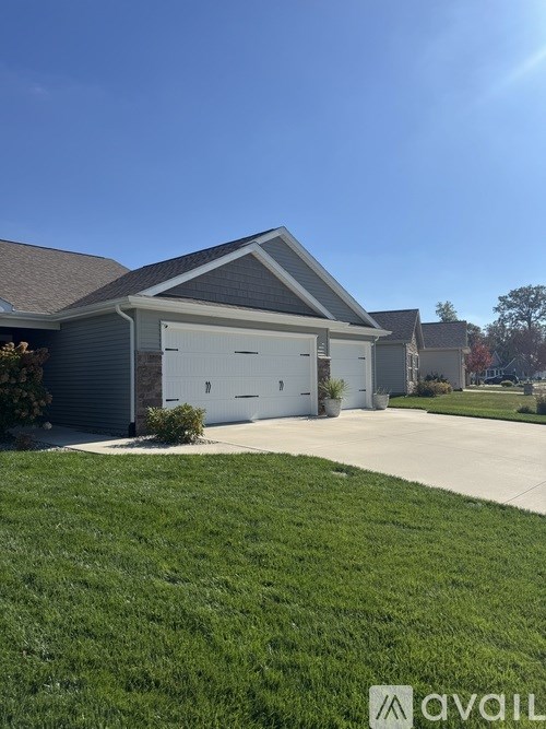 A house with a garage and a driveway in front.