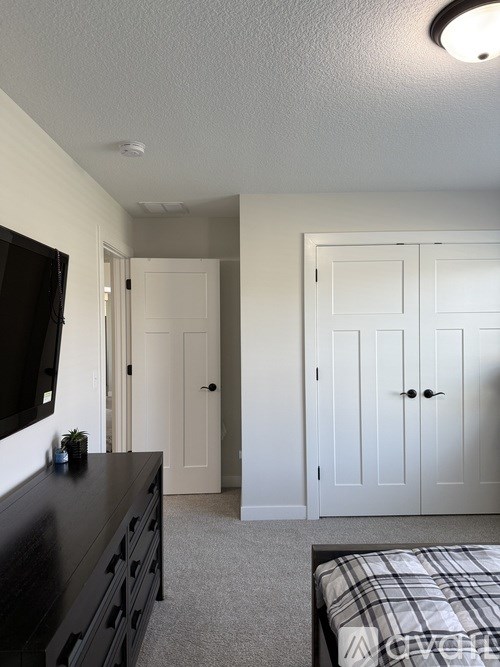 A black dresser with a flat screen TV on top of it.