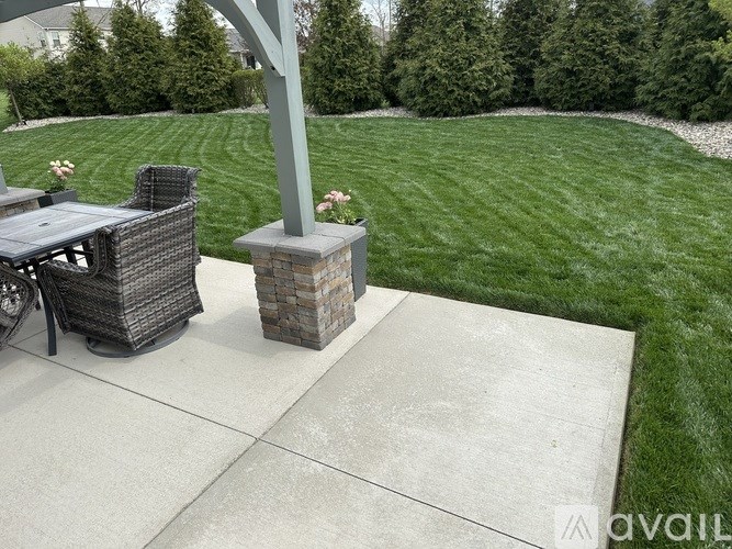 A patio with a table and chairs and a pillar.