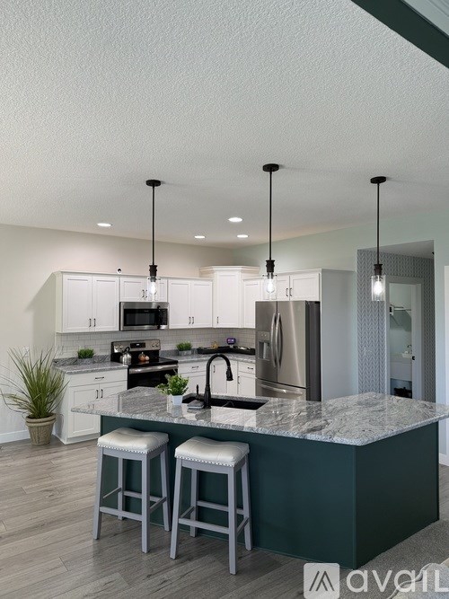 A kitchen with a marble countertop and stainless steel appliances.
