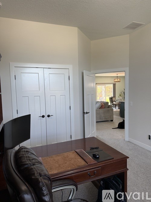 A room with a desk and a chair in it.