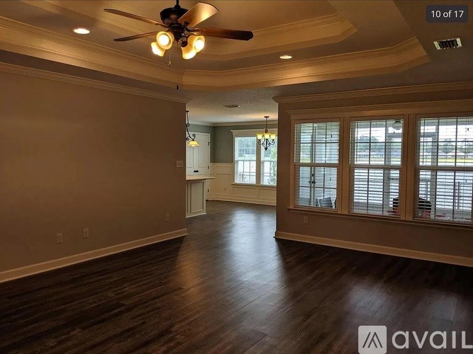 A spacious room with a ceiling fan and wooden flooring.