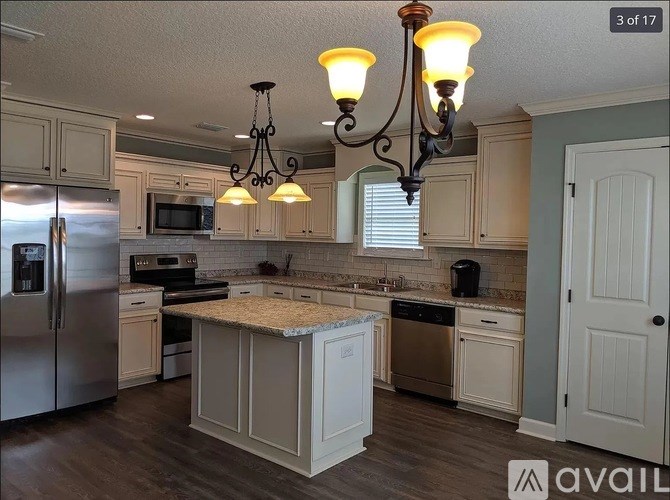 A kitchen with a granite countertop and a chandelier.