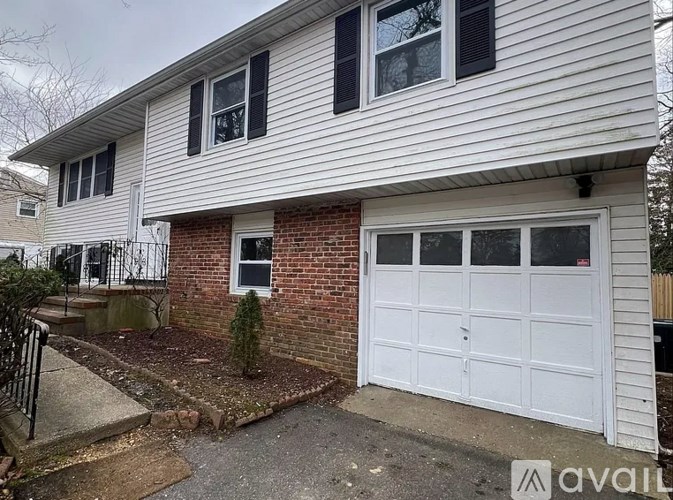 A house with a white garage door and a brick wall.
