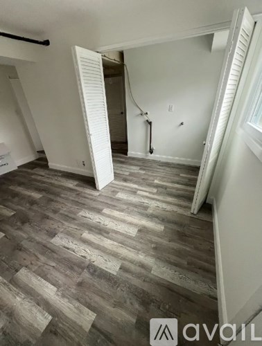 A room with a wooden floor and a white door.