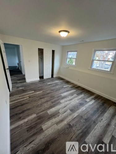 A room with wooden flooring and a window.