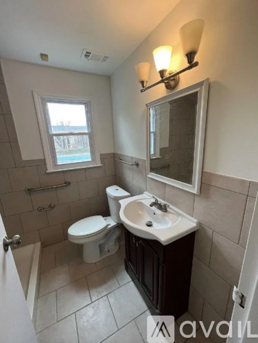 A bathroom with a toilet, sink, and mirror.