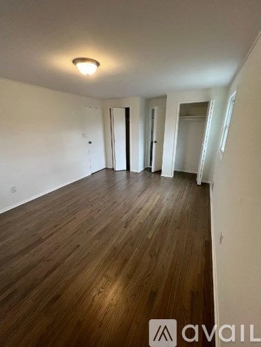A room with wooden flooring and white walls.
