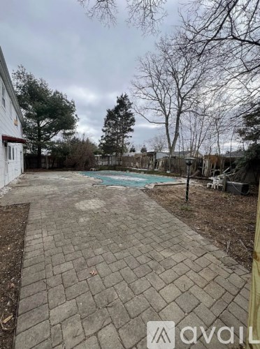 A backyard with a pool and a patio.