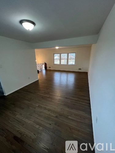A room with wooden flooring and a window.