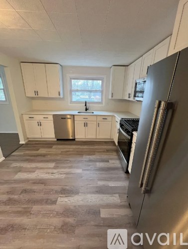 A kitchen with a refrigerator on the right side.