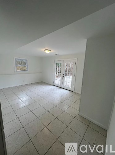 A room with tiled flooring and a window with blinds.