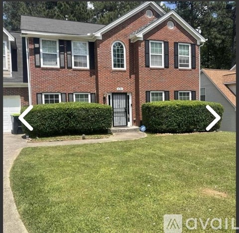 A red brick house with a white door and windows.